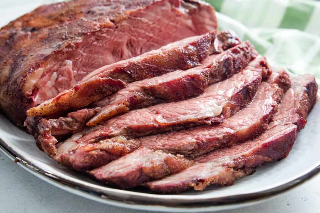 Smoked New York Strip Roast sliced and laying on platter