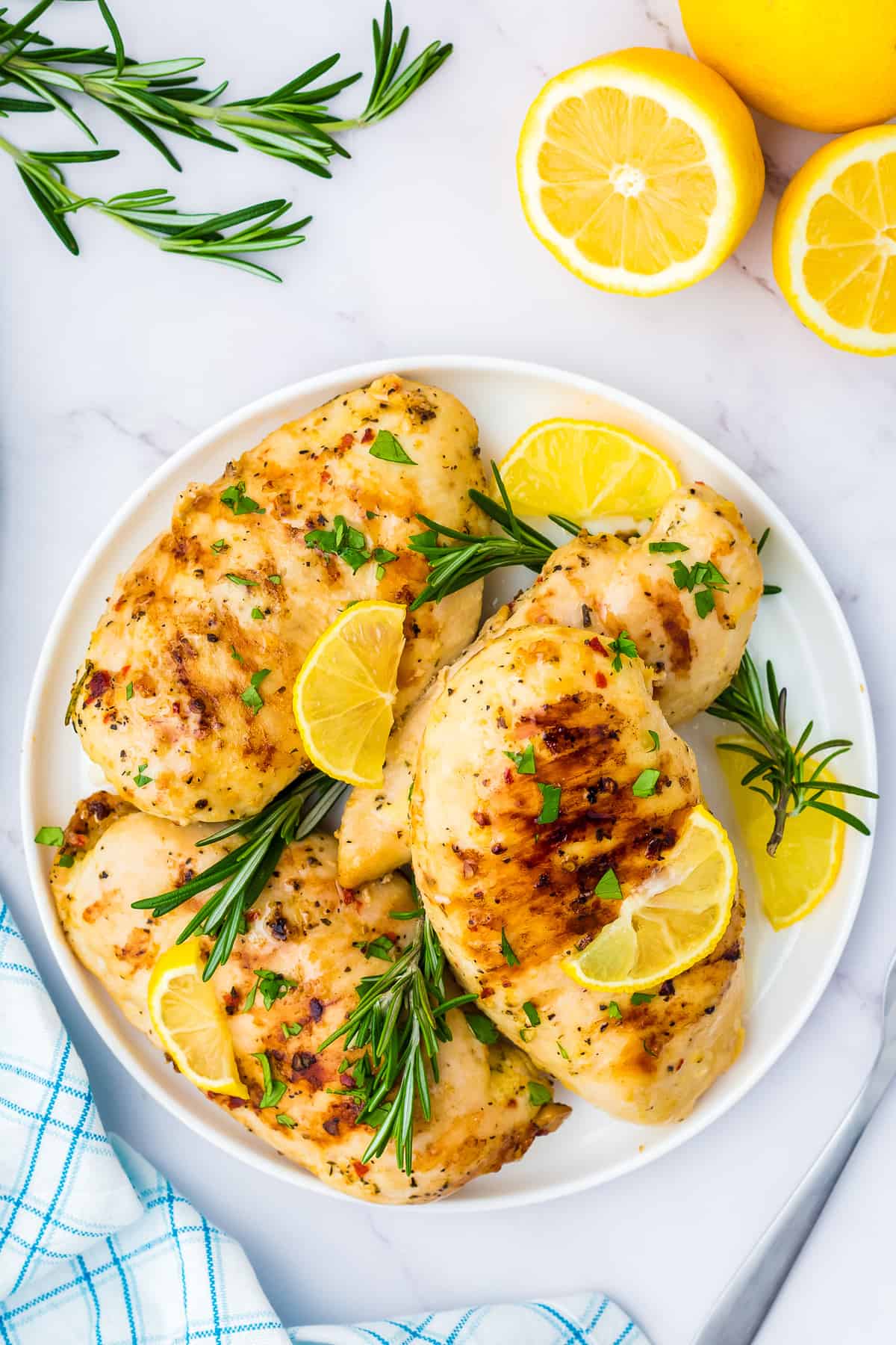 Overhead platter of grilled chicken breast with lemon