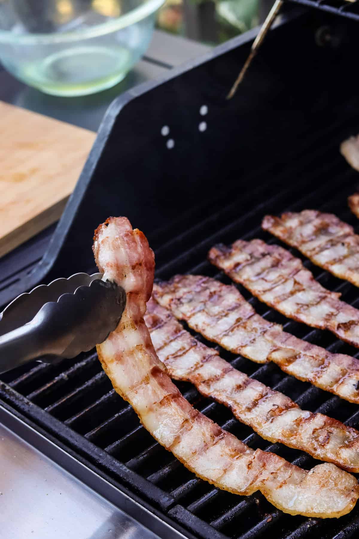Flipping bacon on grill