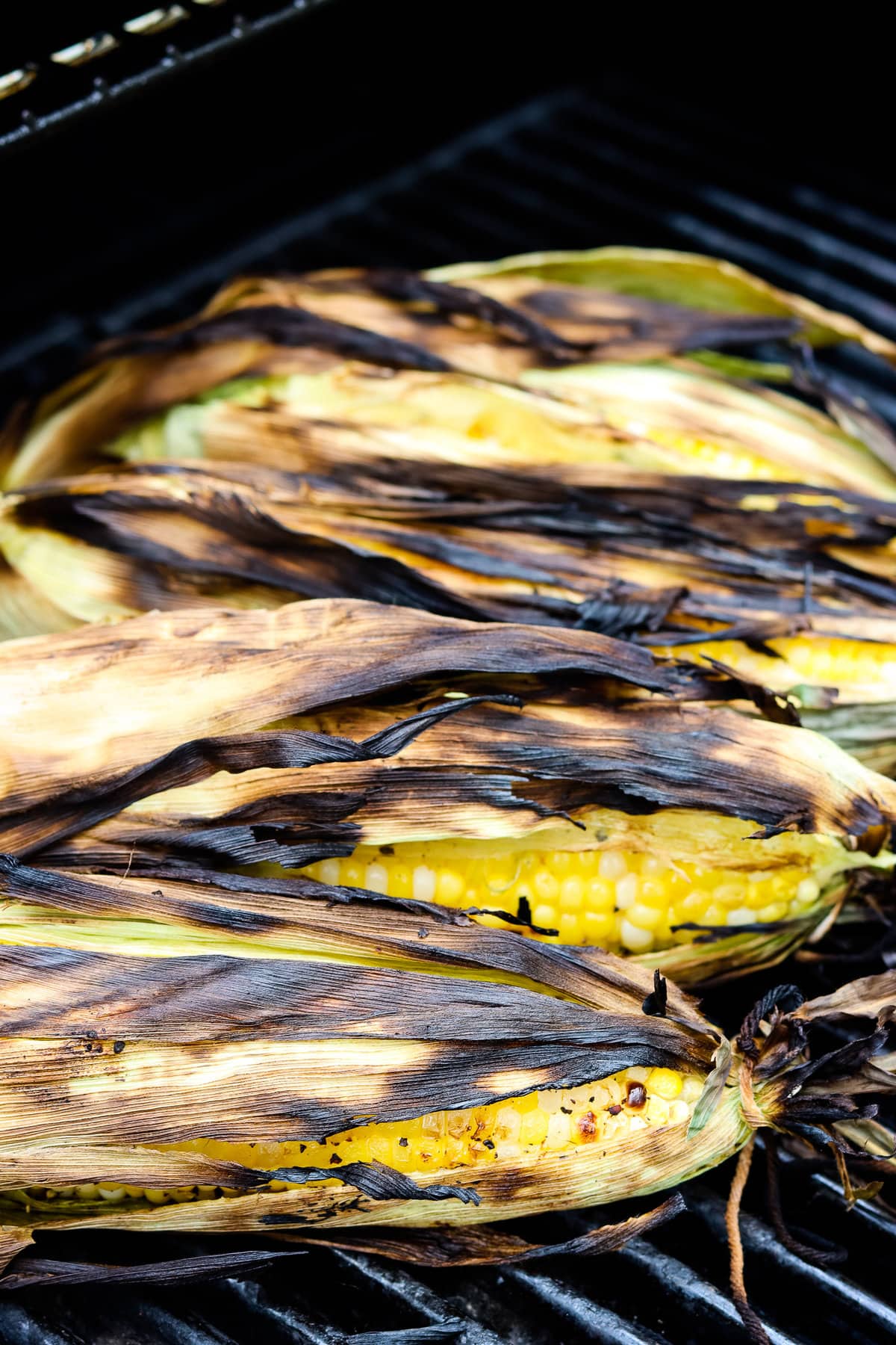 Corn on the cob with husk on grill