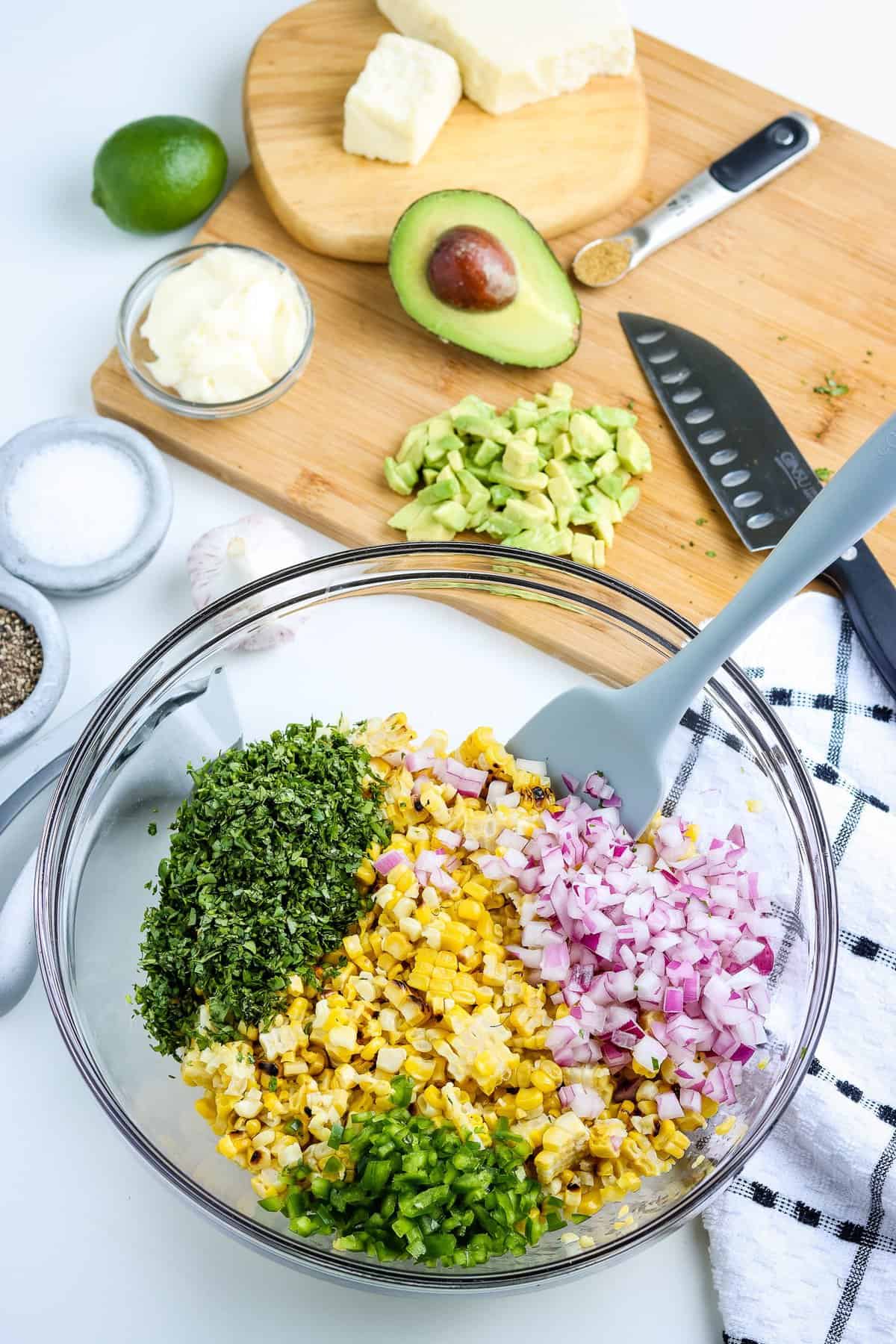 Glass bowl with ingredient for corn salad before stirring