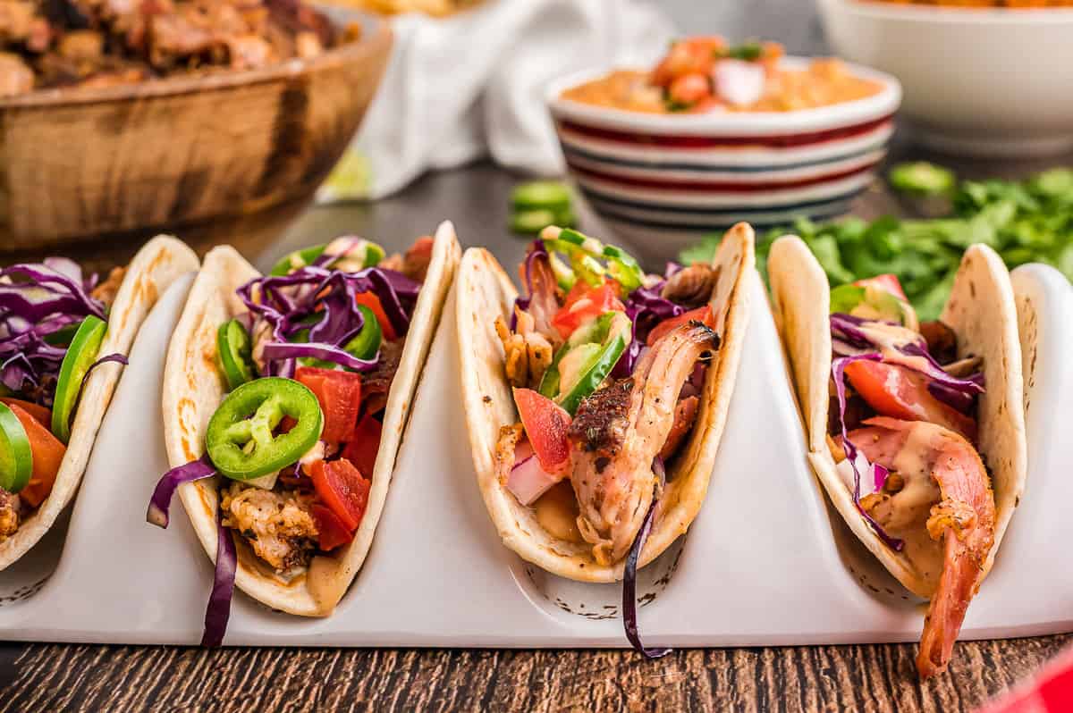 Three smoked pork tacos in taco stand