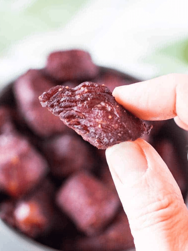 Two Fingers Holding a piece of Teriyaki Smoked Steak Bites