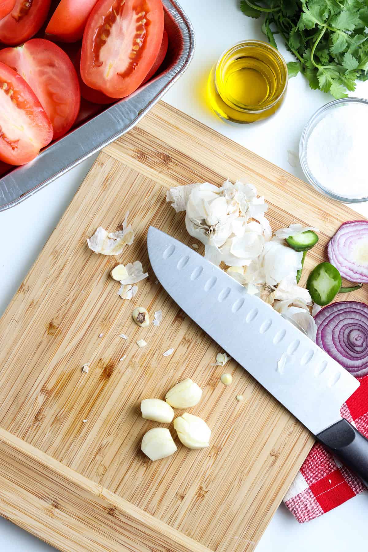 Cutting Fresh Garlic Cloves on Cutting Board for Smoked Salsa Recipe