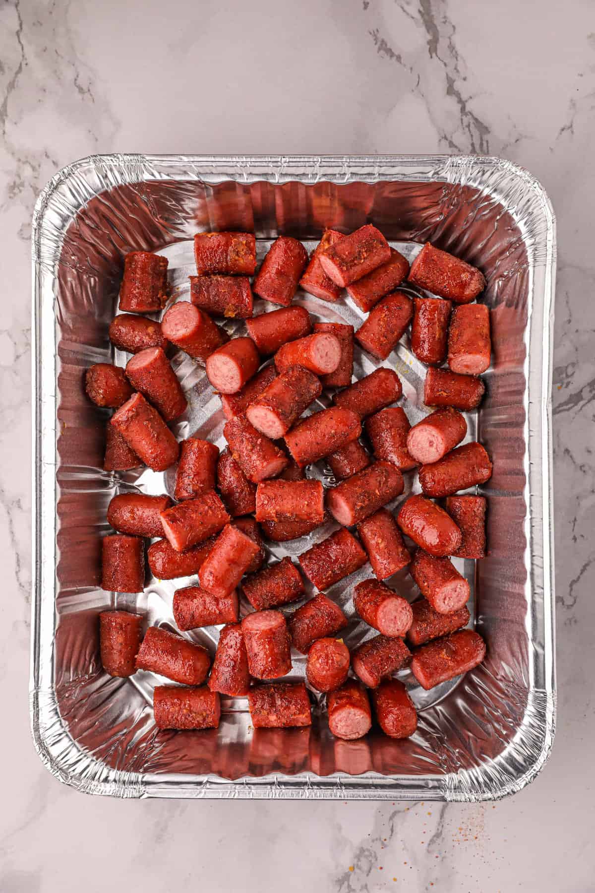 Slicing Smoked Hot Dogs and Placing in Disposible Pan