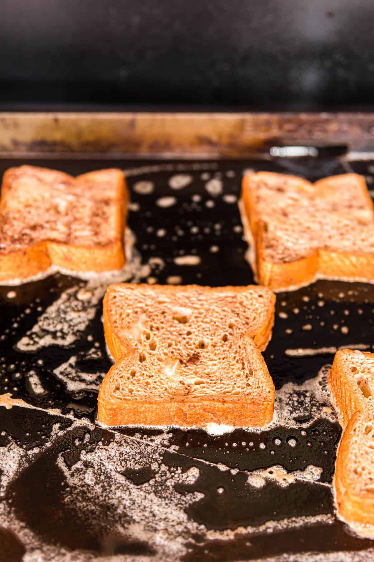 Browning French Toast Bread Slices on Buttered Blackstone Griddle