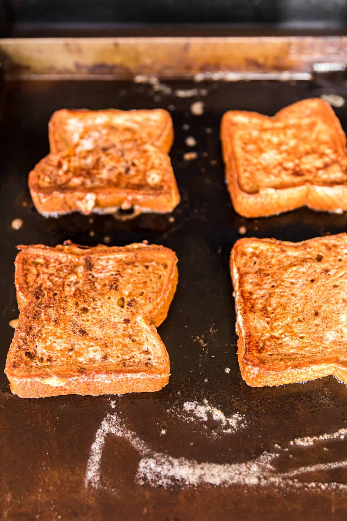 Golden Brown French Toast Slices on Buttered Blackstone Griddle