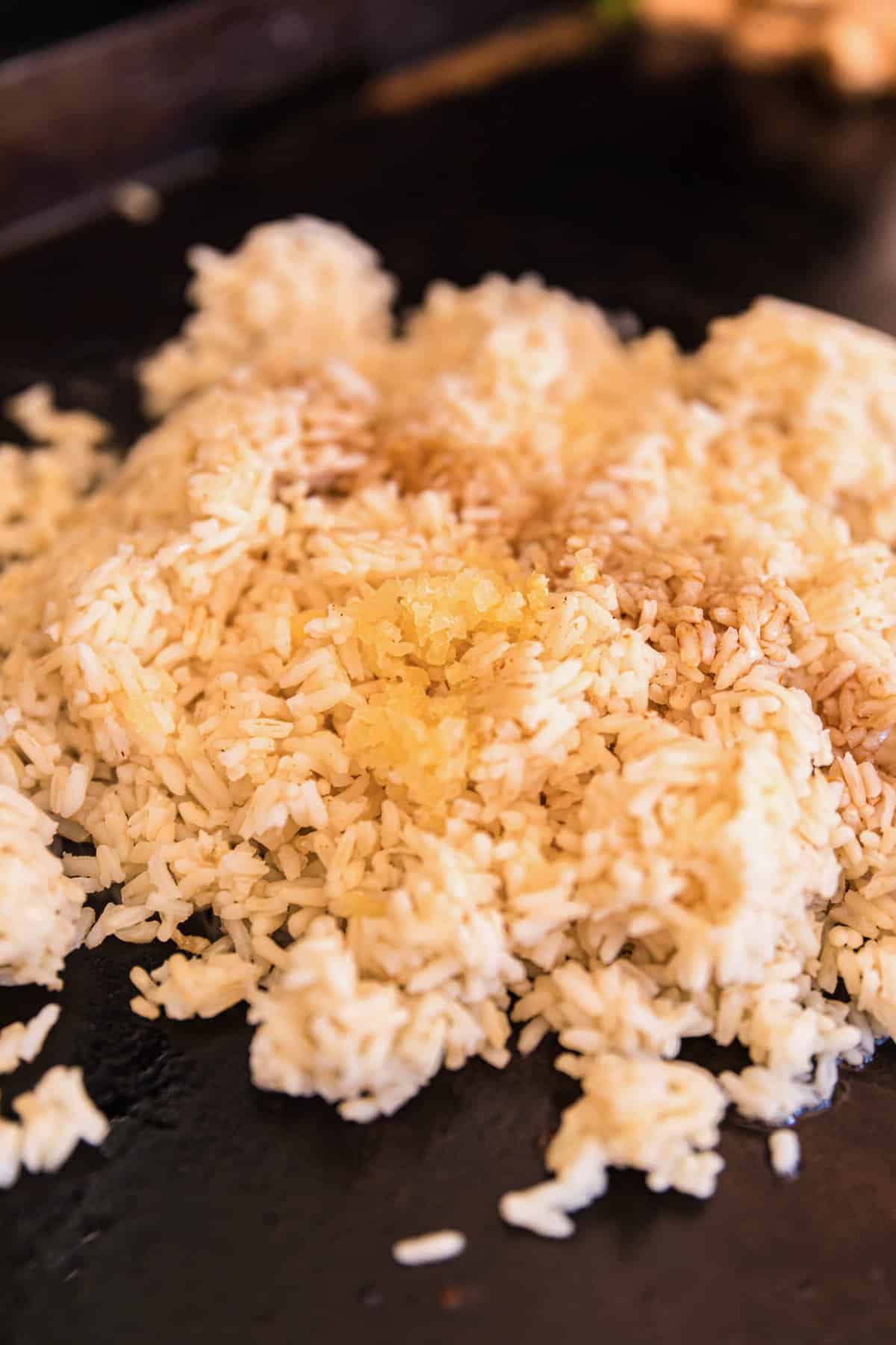 Adding Cold White Rice to Mixture for Blackstone Chicken Fried Rice Recipe
