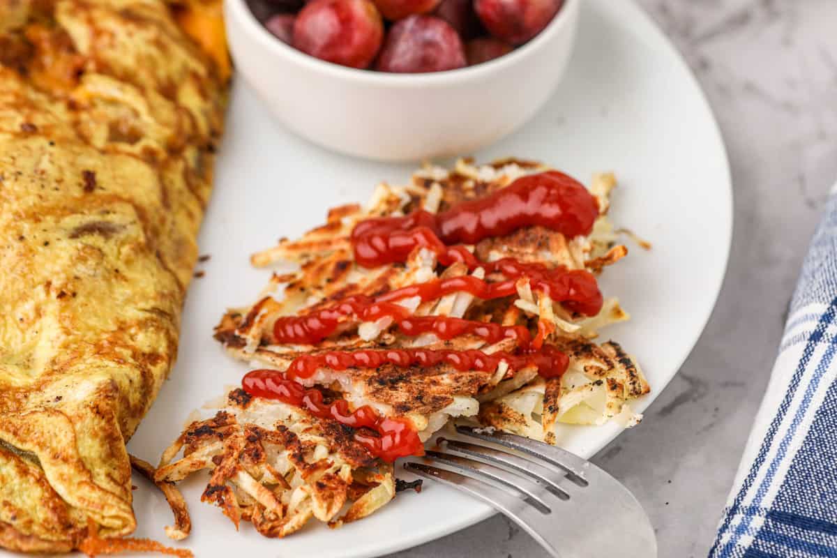 Hash Browns on Blackstone Drizzled with Ketchup Ready for the First Bite