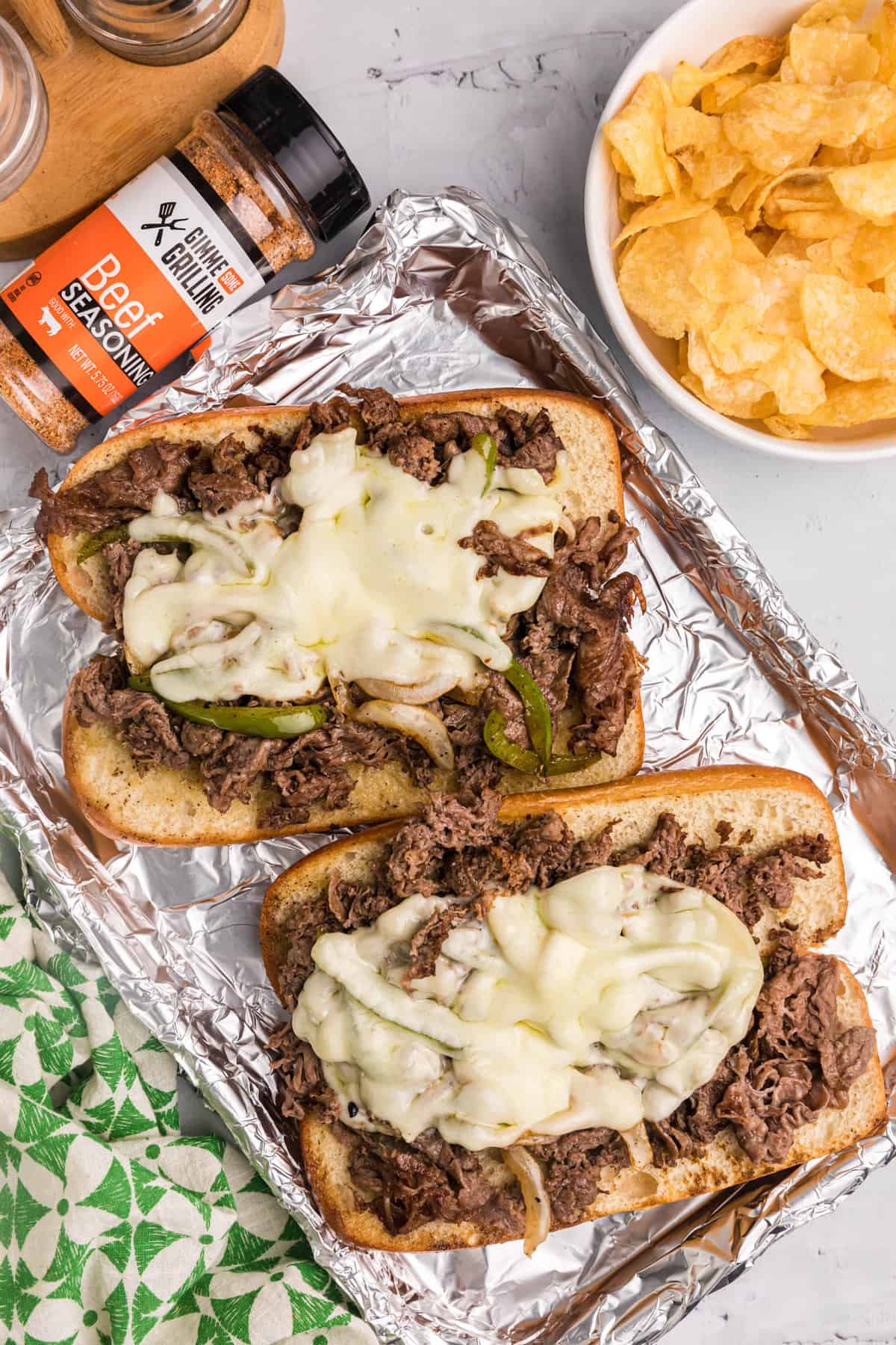 Open faces Picture perfectly cooked beef, melted cheese, and savory caramelized onions, all expertly crafted on the Blackstone griddle. Elevate your sandwich game with a mouthwatering Blackstone Philly Cheesesteaks on tinfoil-lined tray.