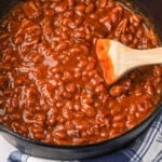 Traeger Baked Beans being stirred with wooden spoon