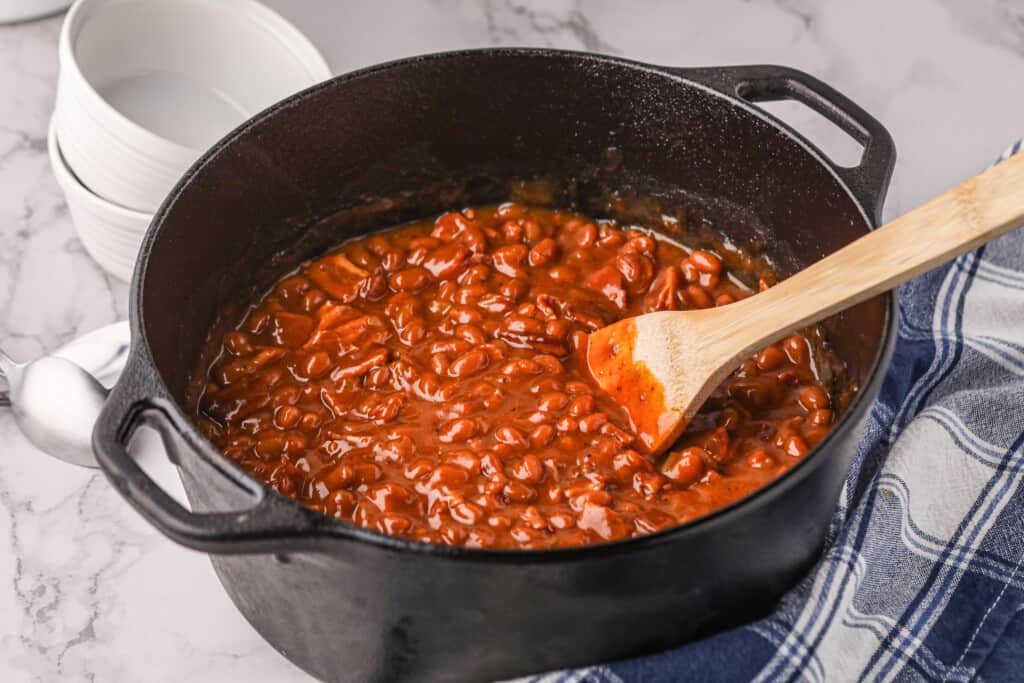 Smoked BBQ Beans in Dutch Oven with Wooden Spoon
