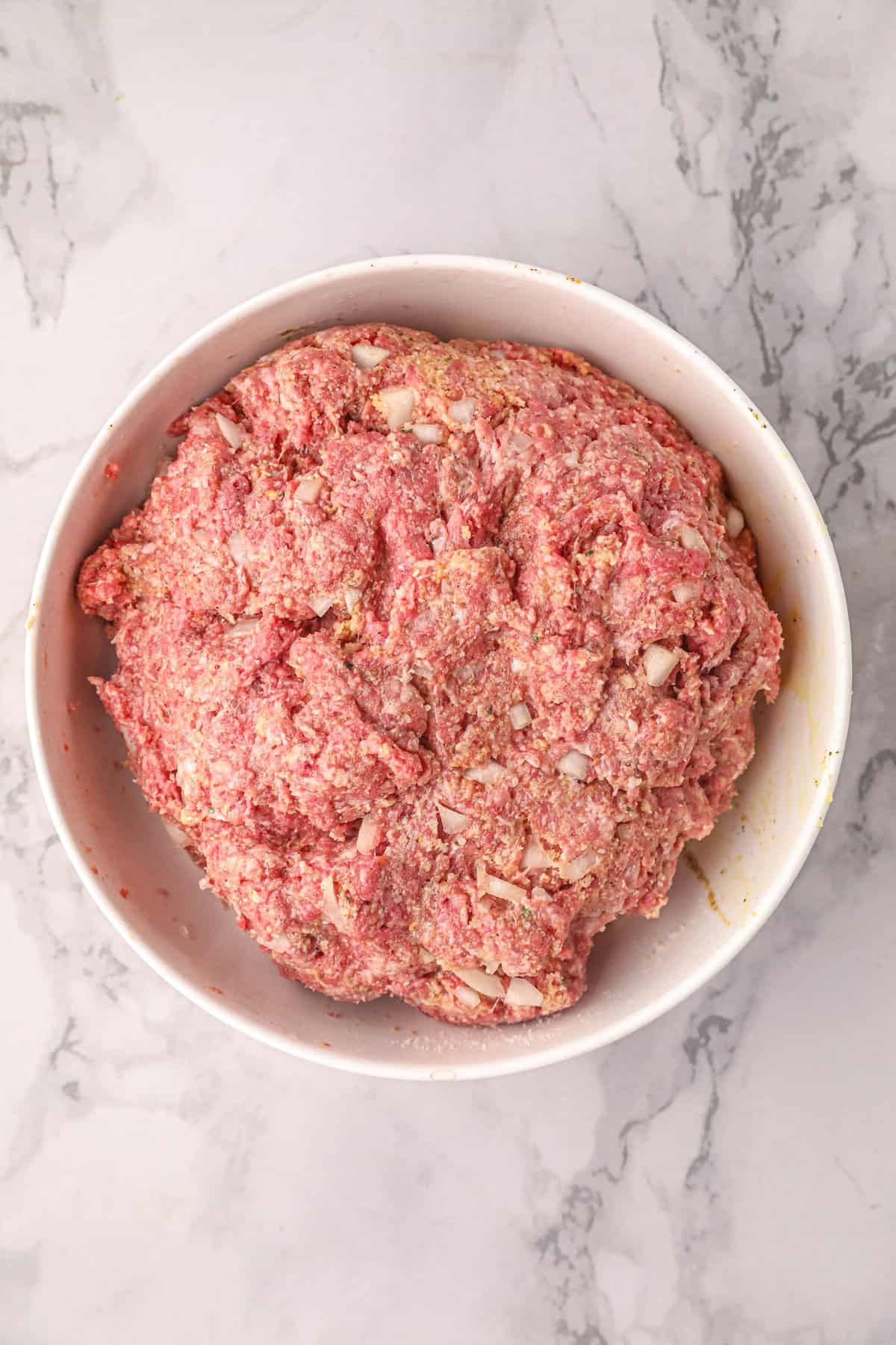 Combined meatball ingredients in mixing bowl for Smoked Stuffed Meatballs