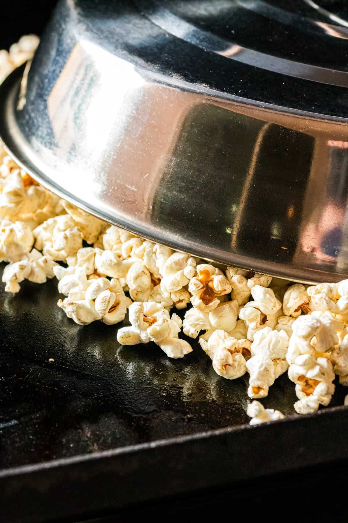 Covering popcorn kernels with cooking dome on Blackstone for Blackstone Popcorn recipe