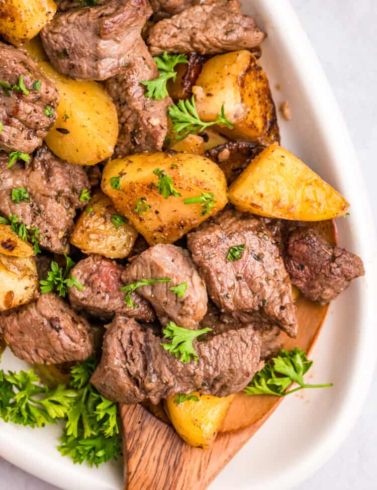 Steak and Potatoes on the Blackstone in a serving bowl with a wooden spoon