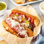 Smoked Brats with buns and all the fixings in a serving dish