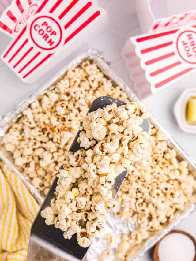 Using Blackstone spatula to scoop popped popcorn from tinfoil lined tray