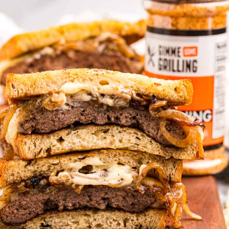Blackstone Patty Melt Sandwiches cut and stacked on cutting board