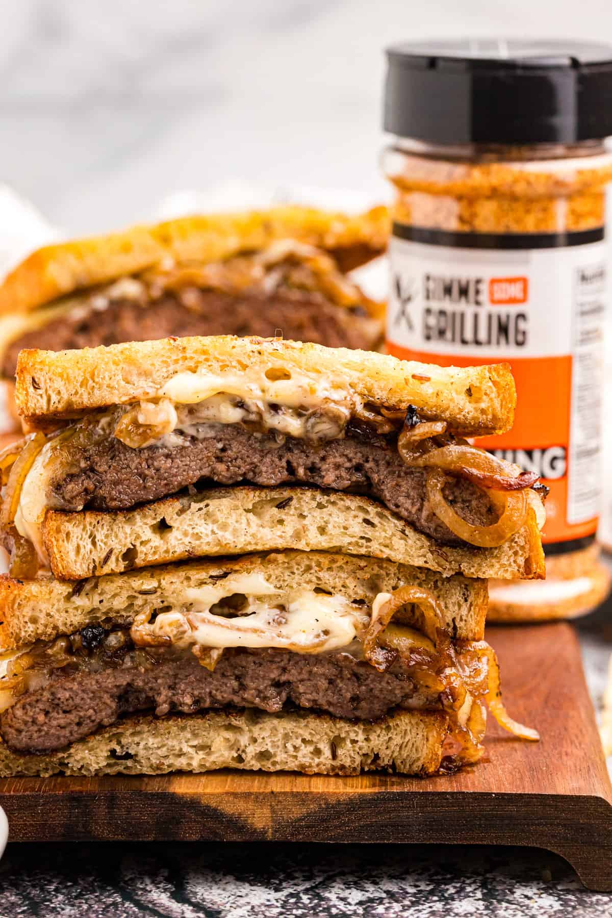 Blackstone Patty Melt Sandwiches cut and stacked on cutting board