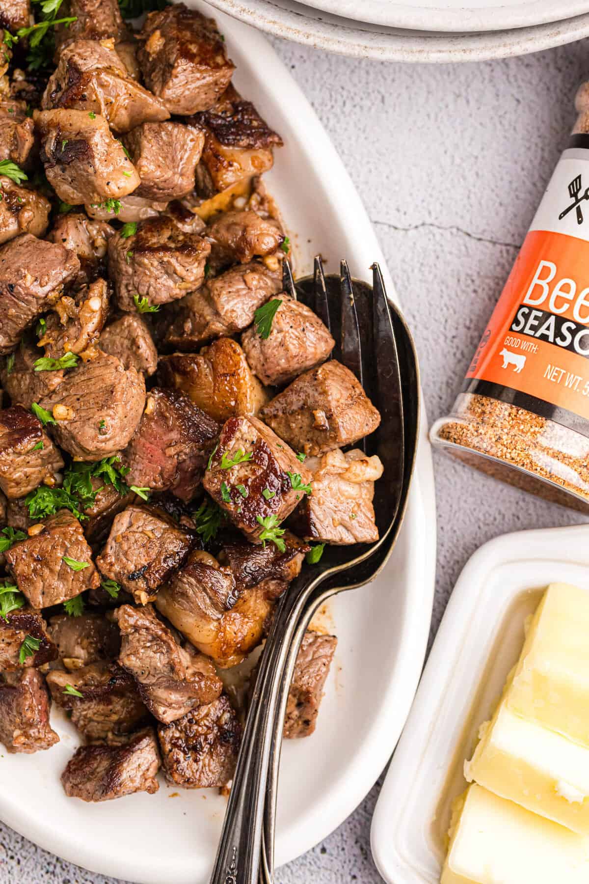 Blackstone Steak Bites on serving plate with butter and beef seasoning