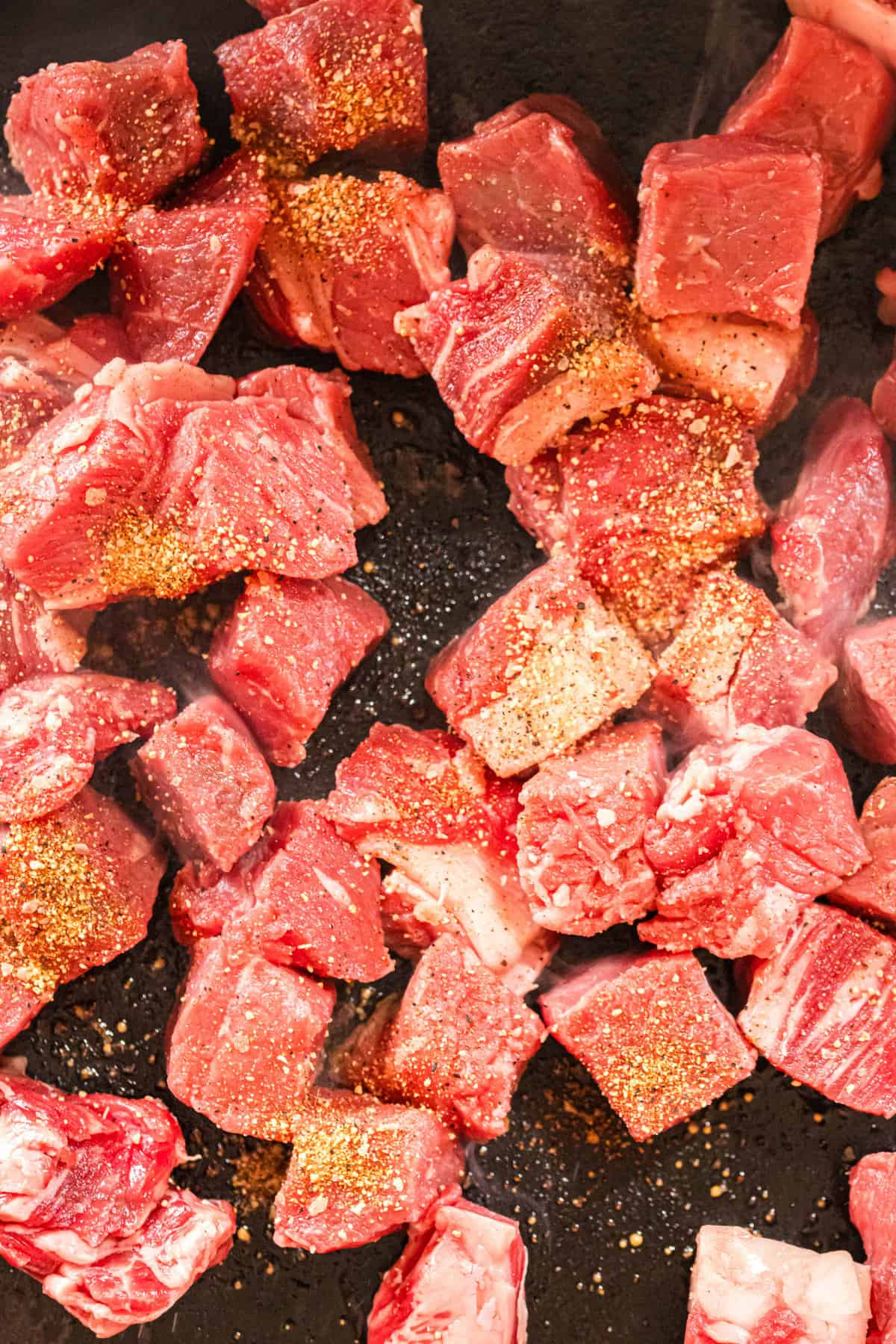 Cubed sirloin steak cooking on Blackstone in olive oil and Beef Seasoning for Blackstone Steak Bites