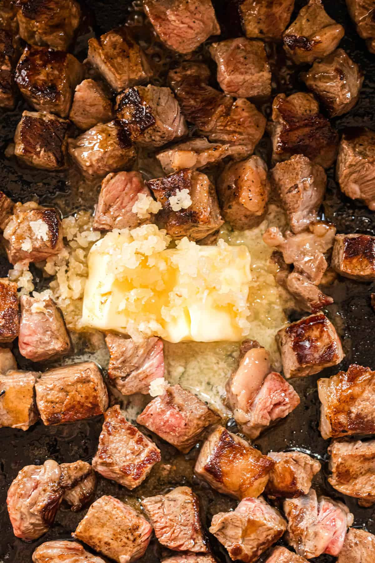 Adding salted butter to the Blackstone Steak Bites