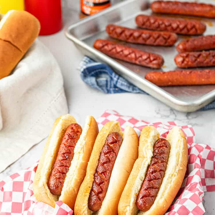 Smoked Hot Dogs on the Traeger in buns arranged in paper lined serving tray