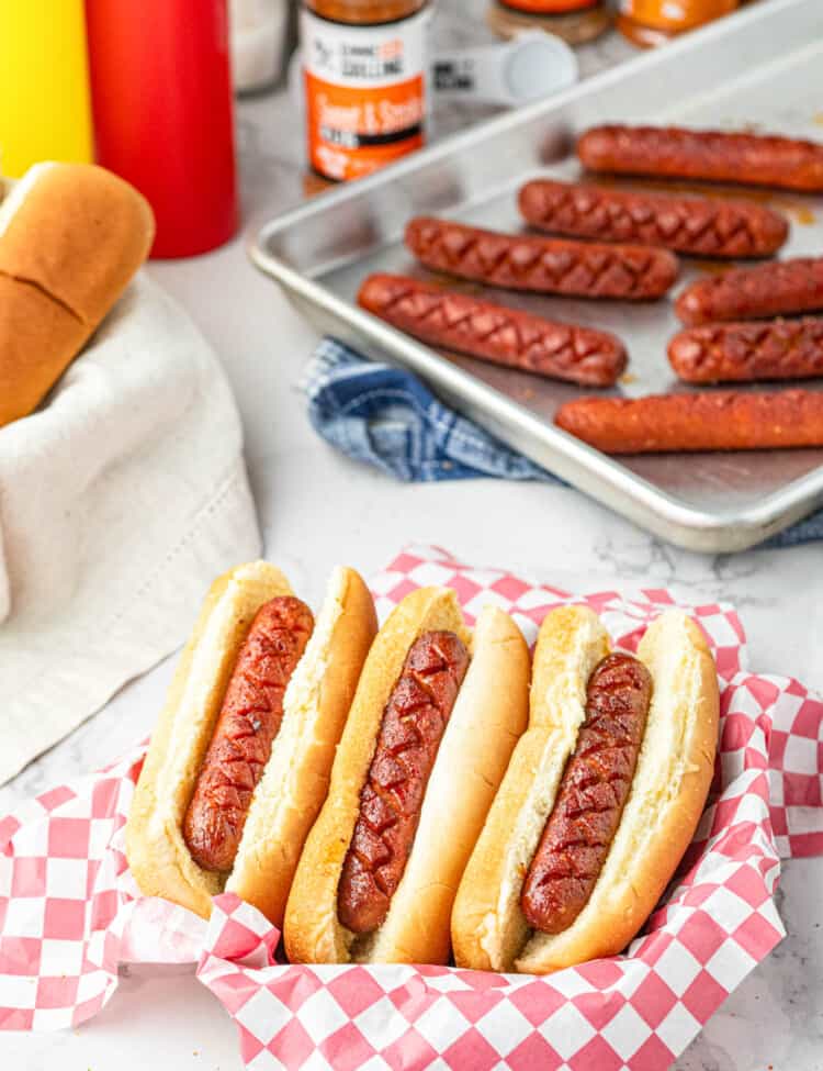 Smoked Hot Dogs on the Traeger in buns arranged in paper lined serving tray