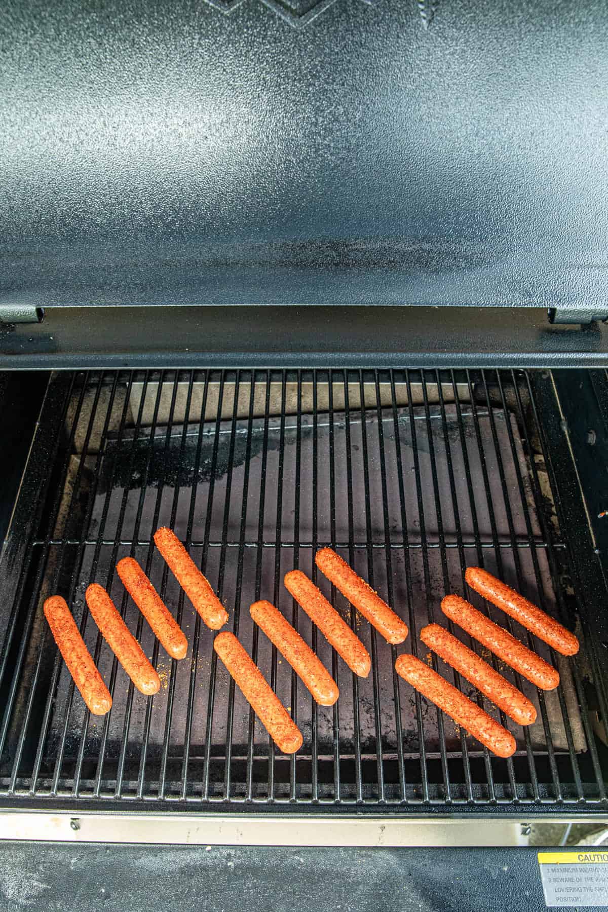 Laying seasoned hot dogs on Traeger for Smoked Hot Dogs recipes