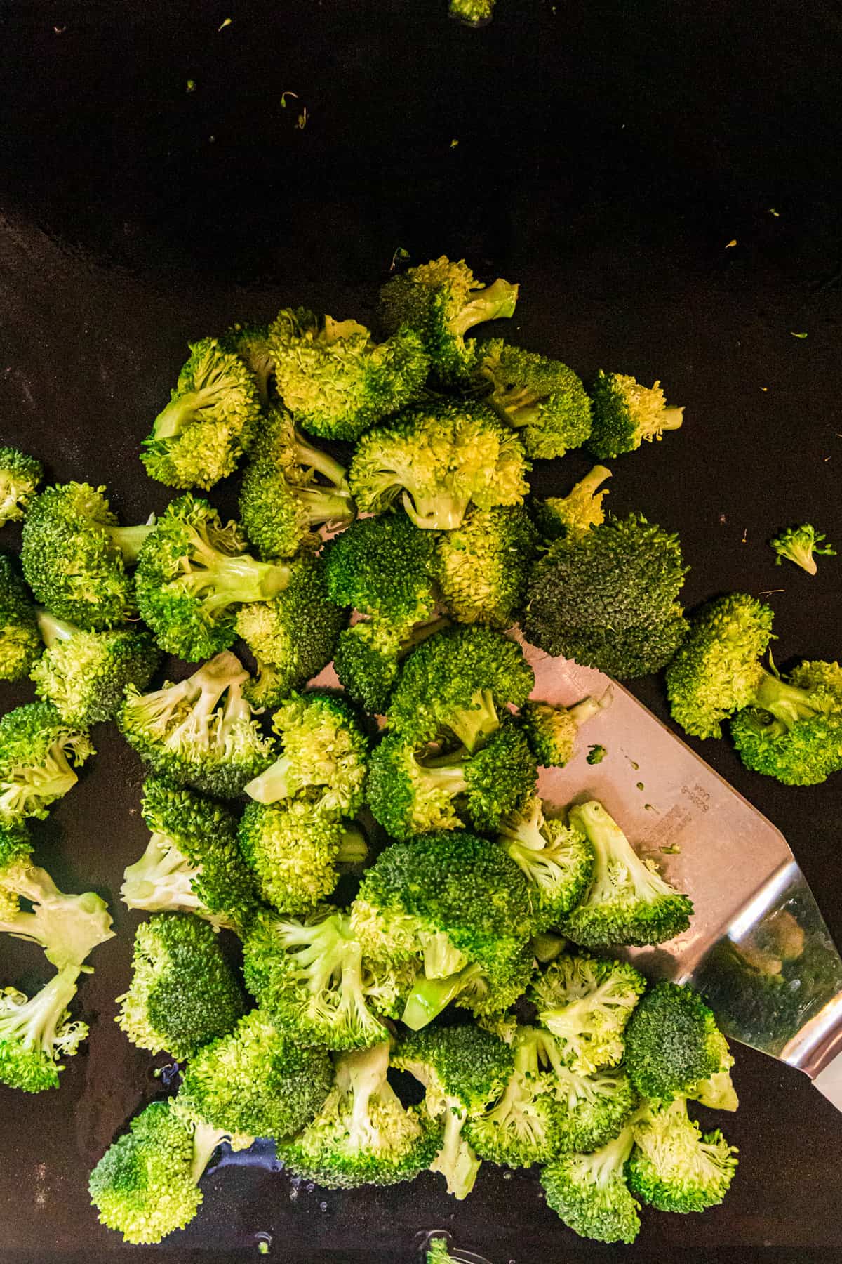 Tossing broccoli florets on griddle for Blackstone Beef & Broccoli