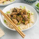 Blackstone Teriyaki Chicken in a bowl over rice with chopsticks