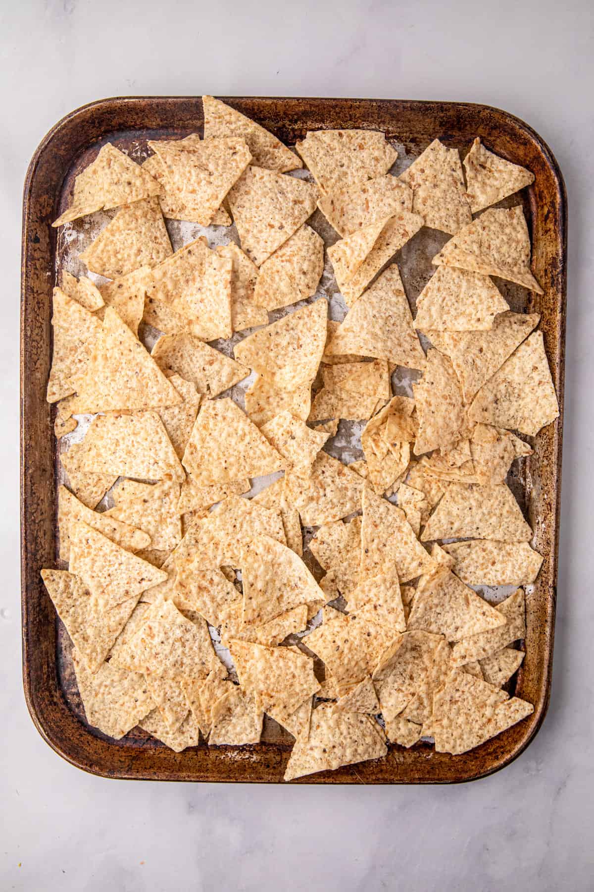 Lining cooking sheet with tortilla chips for Smoked Brisket Nachos recipe