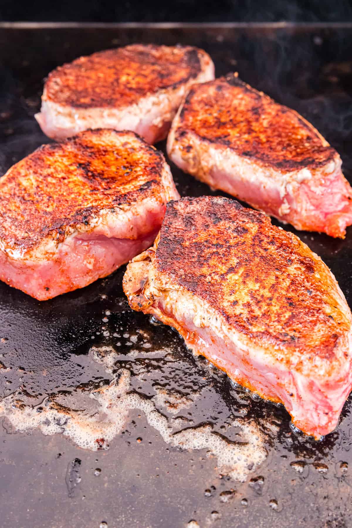 Seasoned pork chops seared to perfection for Pork Chops on the Blackstone