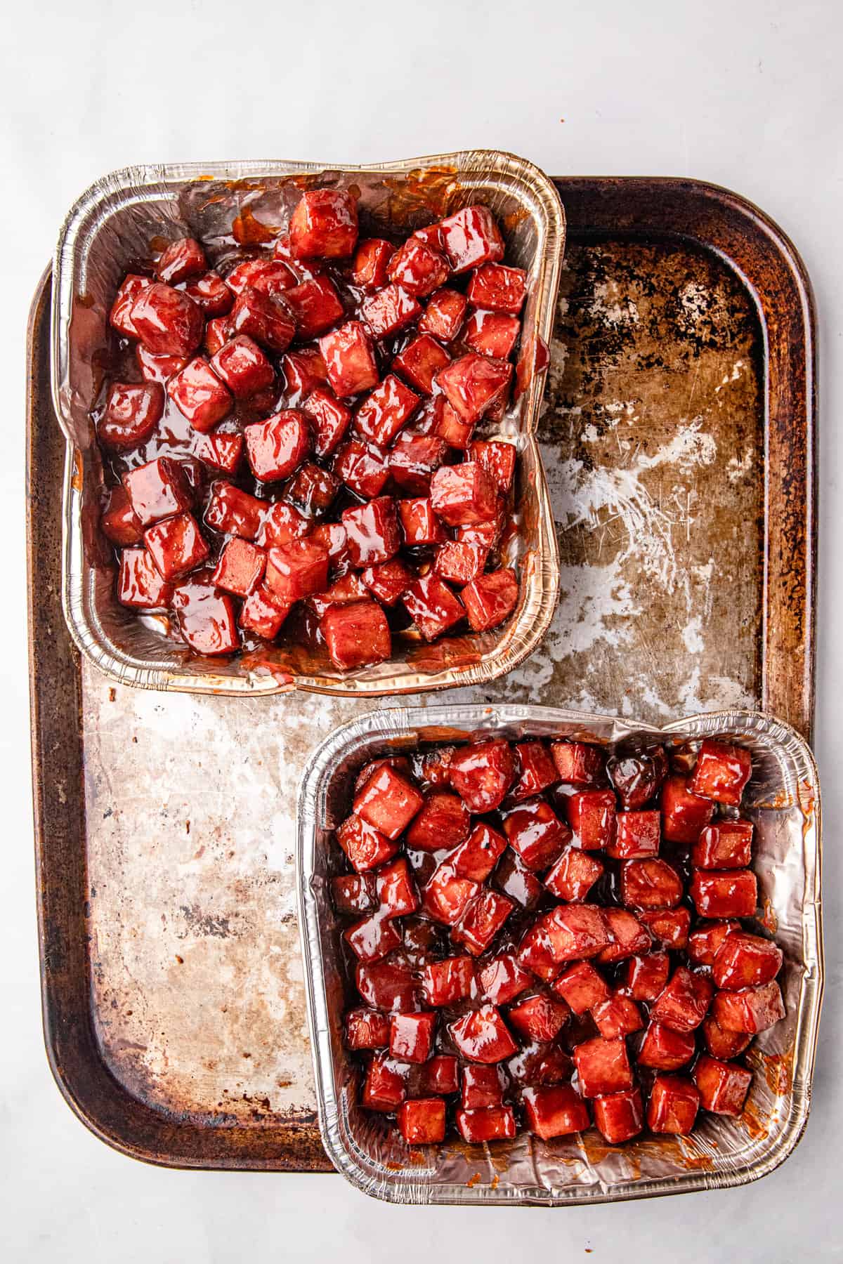 Smoked Burnt Ends in square cooking tins with sauce added