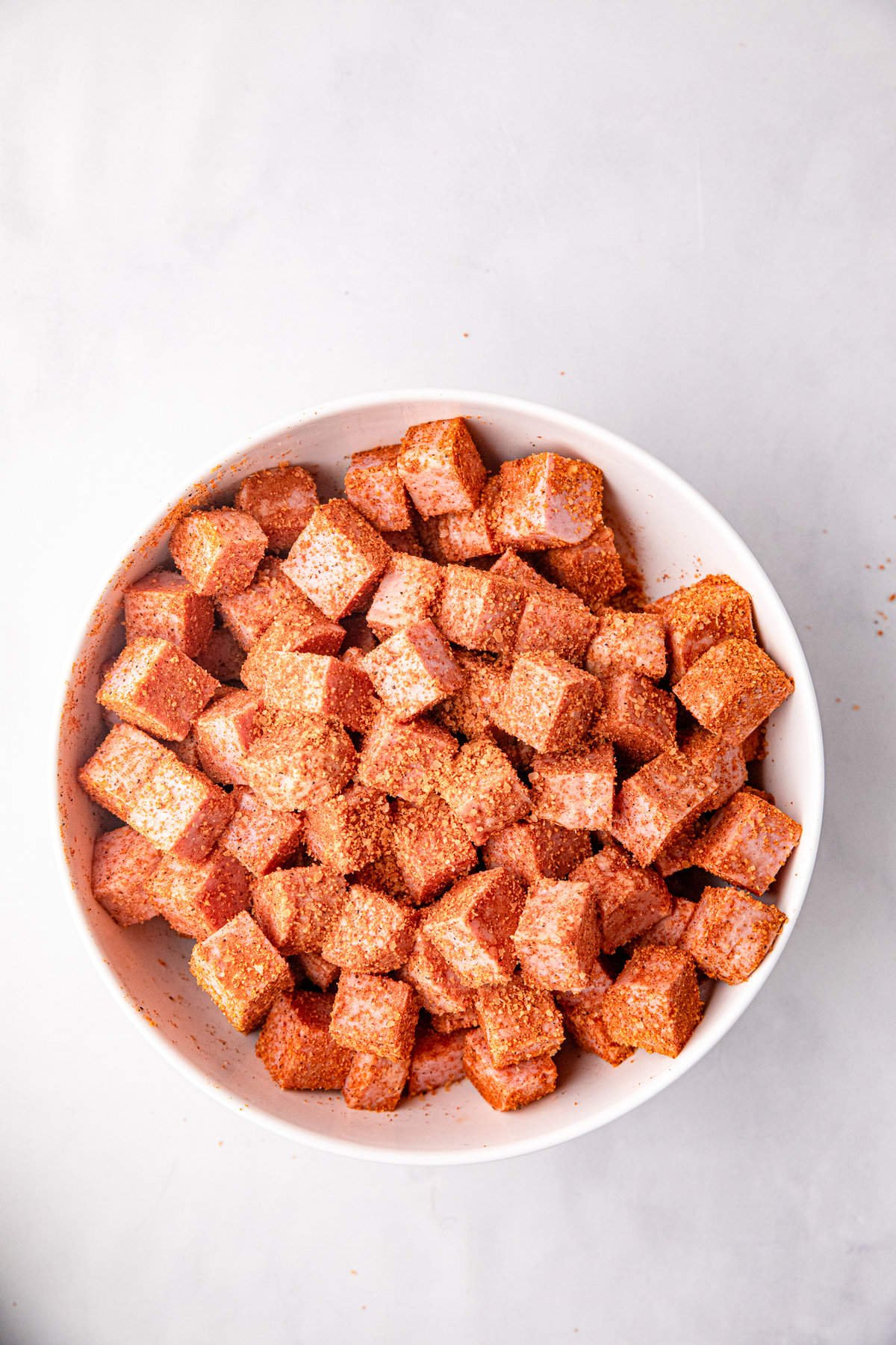 Generously coated Spam pieces with Sweet & Smoky seasoning in bowl