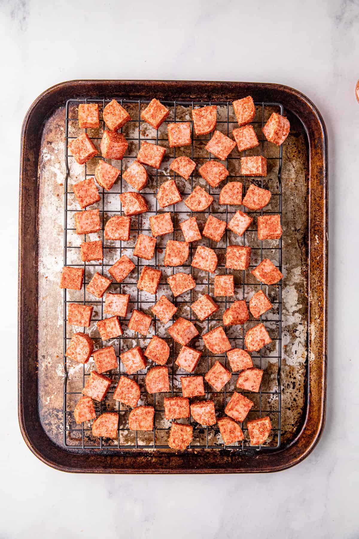 Arranging seasoned Spam pieces on cooking grate on cooking sheet  for Spam Burnt Ends recipe