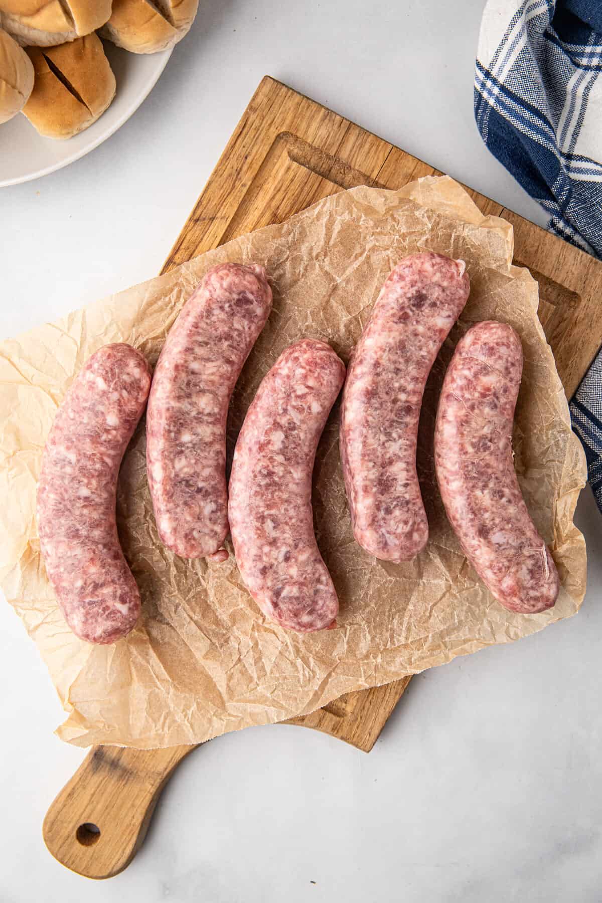 Uncooked sausage links on paper lined cutting board for Smoked Sausage recipe