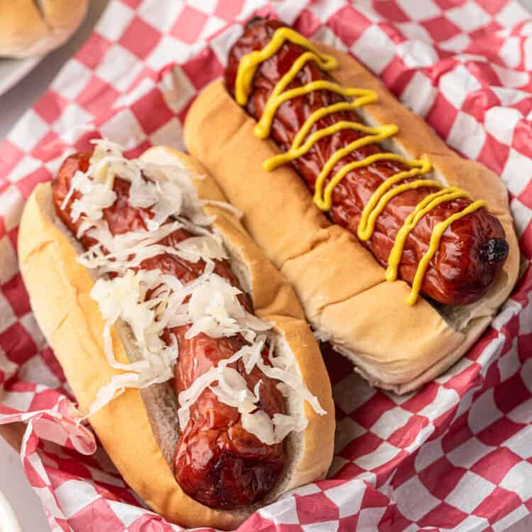 Closeup square image of Smoked Sausage in buns smothered with the fixings.