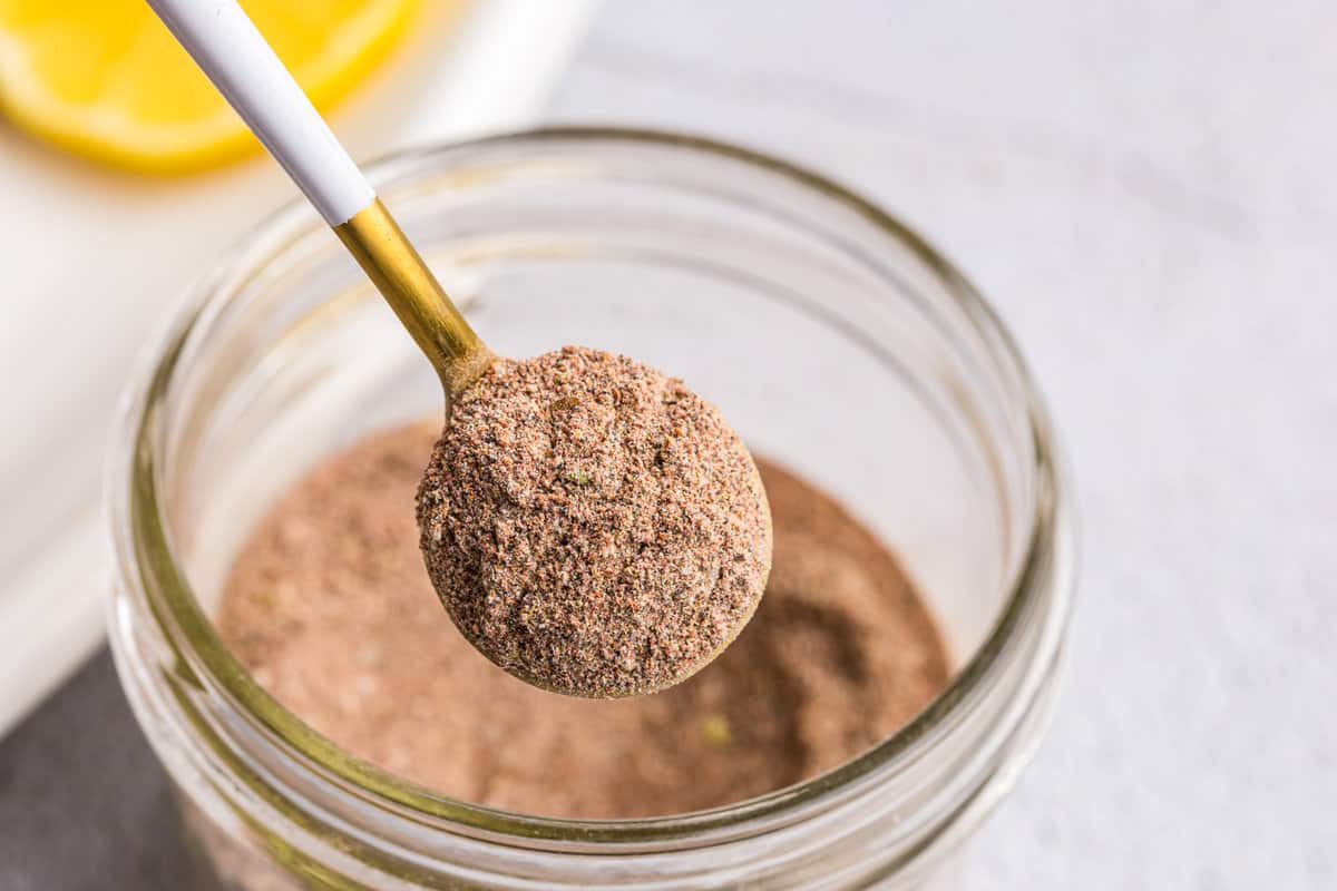 Scooping Blackened Seasoning from small jar with spoon