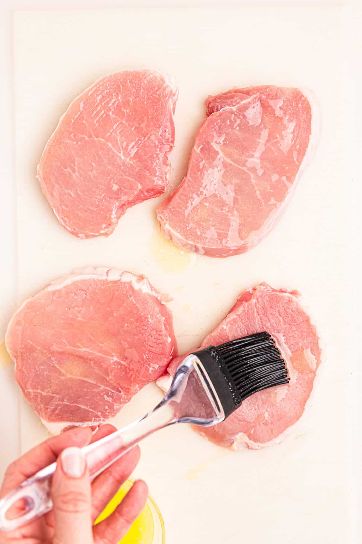 Brushing on butter over pork chops for Blackstone Blackened Pork Chops recipe
