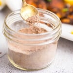 Closeup square image of Blackened Seasoning in jar with spoon