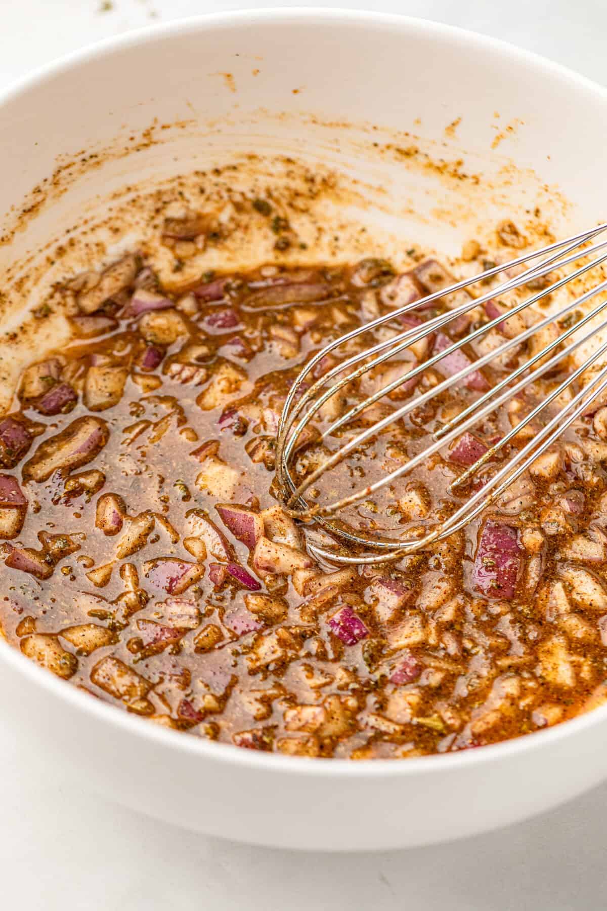 Whisking marinade ingredients in bowl for Pollo Asado recipe