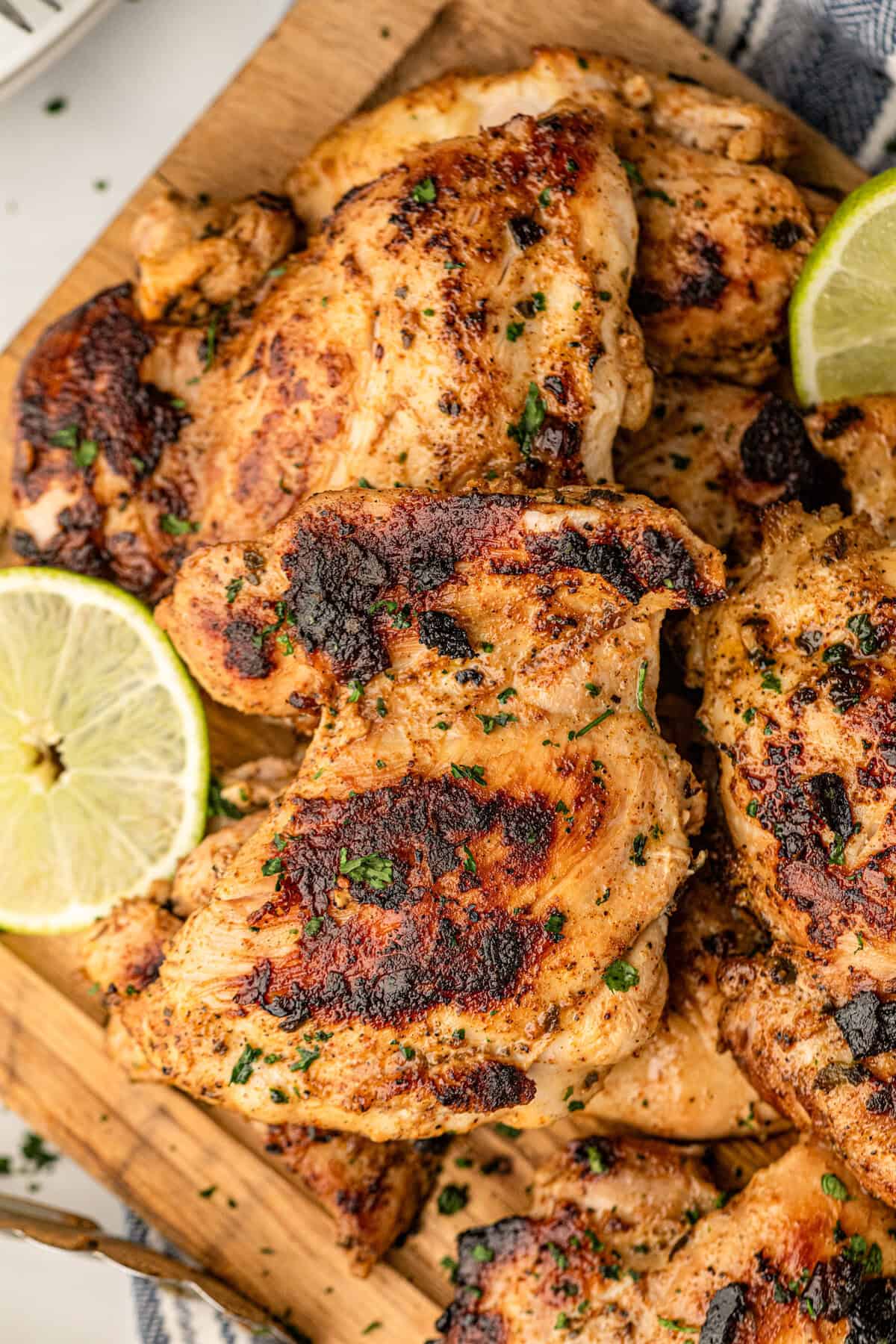Pollo Asado arranged on cutting board with lemon and lime slices