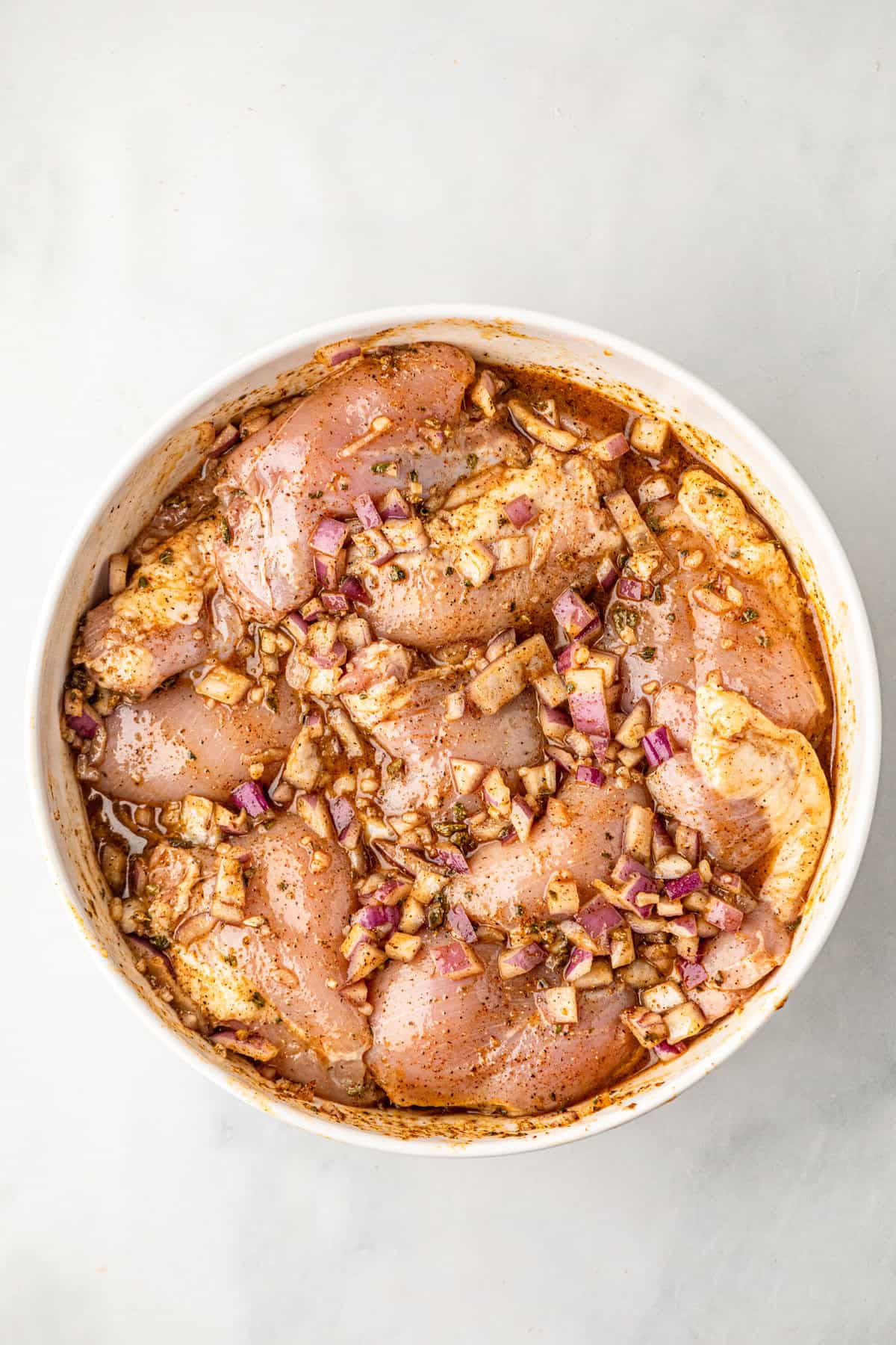 Chicken in marinade bowl for Grilled Pollo Asado recipe