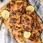 Pollo Asado on wooden cutting board with lemon and lime slices