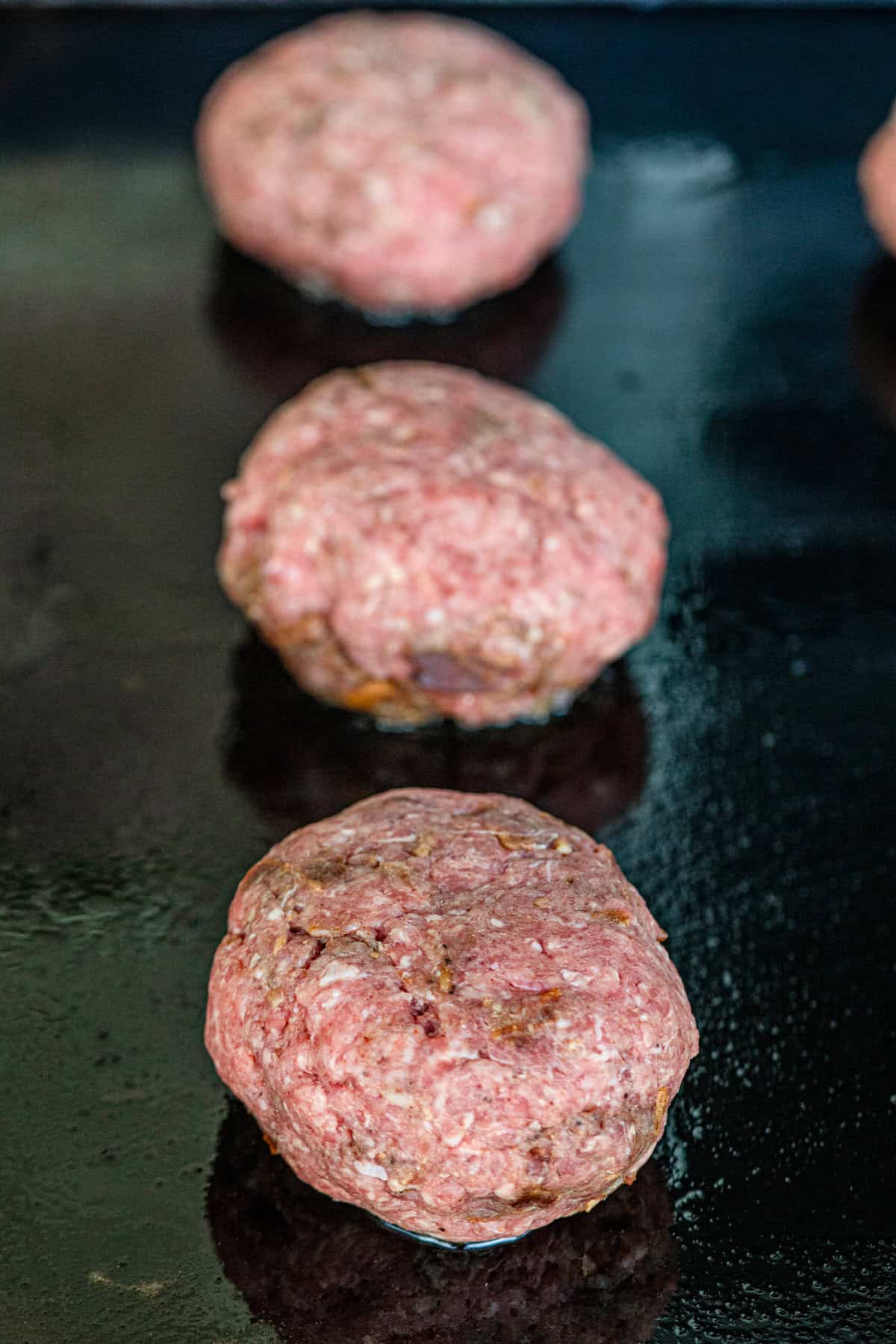Bacon Cheese Stuffed Burger patties on Blackstone