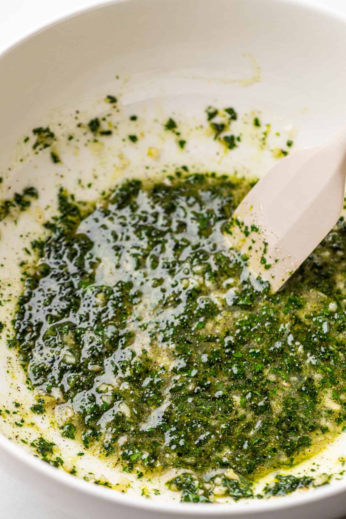 Using spatula to combine Grilled Cilantro Lime Chicken marinade