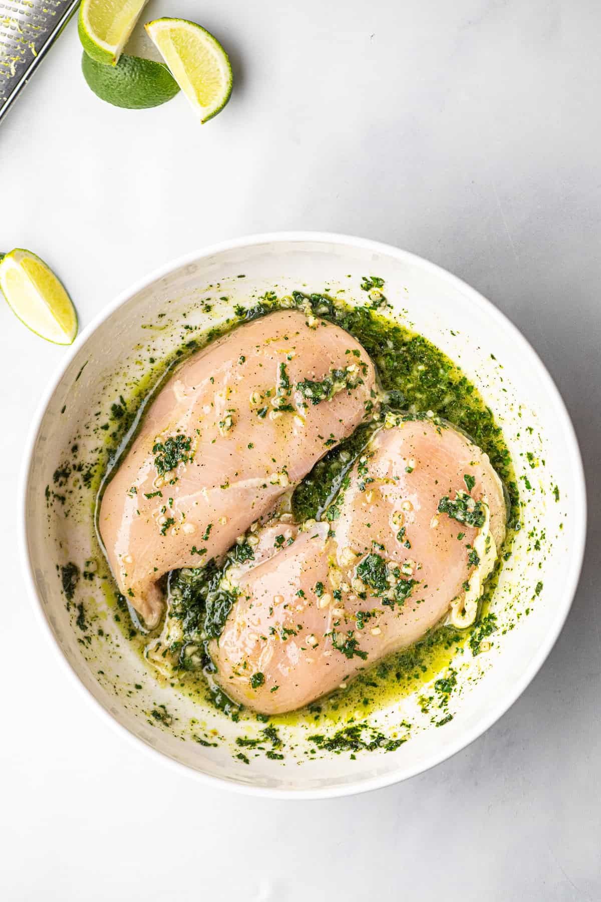 Smothering chicken breasts in combined marinade in shallow dish