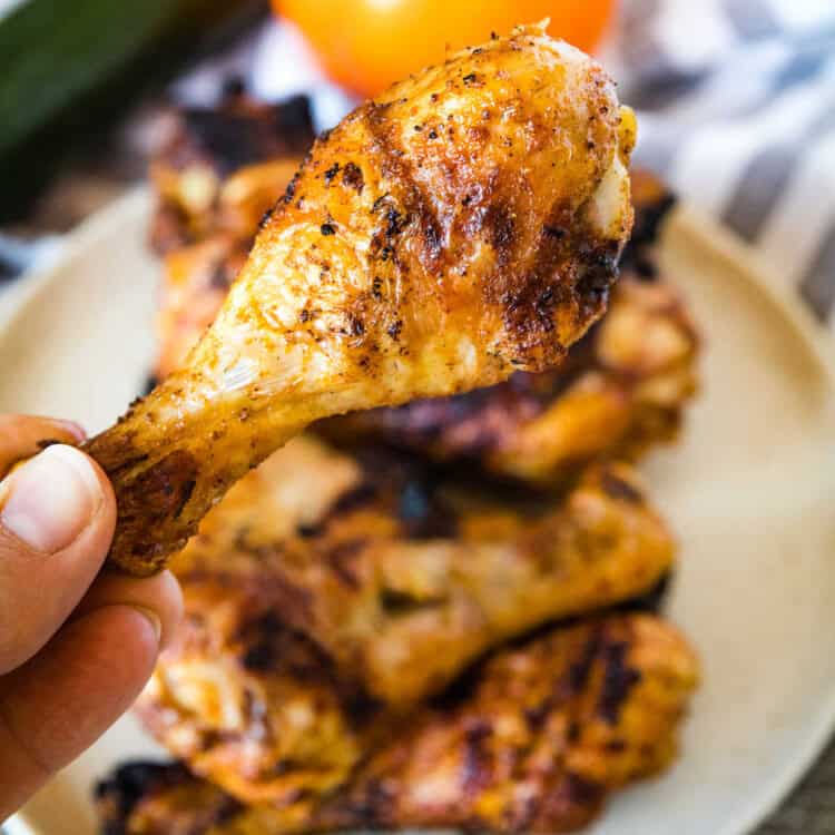 Hand holding a Grilled Chicken Leg