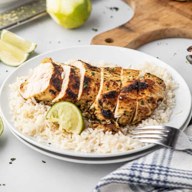 Grilled Cilantro Lime Chicken sliced over rice on dinner plate